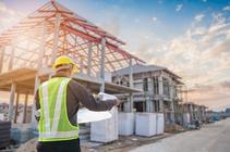 Construction worker reviewing blueprints on job site